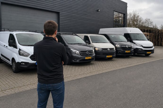 Ondernemer bekijkt verschillende bedrijfswagens om een passende bedrijfswagen voor zijn onderneming te kiezen.
